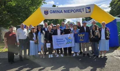 Na zdjęciu delegacje z partnerskich gmin oraz przedstawiciele Gminy Nieporęt stoja pod brama z napisem Gmina Nieporęt podczas Święta Gminy Nieporęt