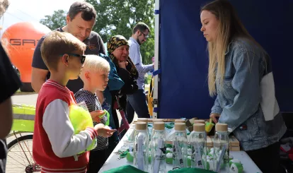 Ludzie stojący przy stoisku promocyjnym Czas na Eko Nieporęt podczas święta gminy